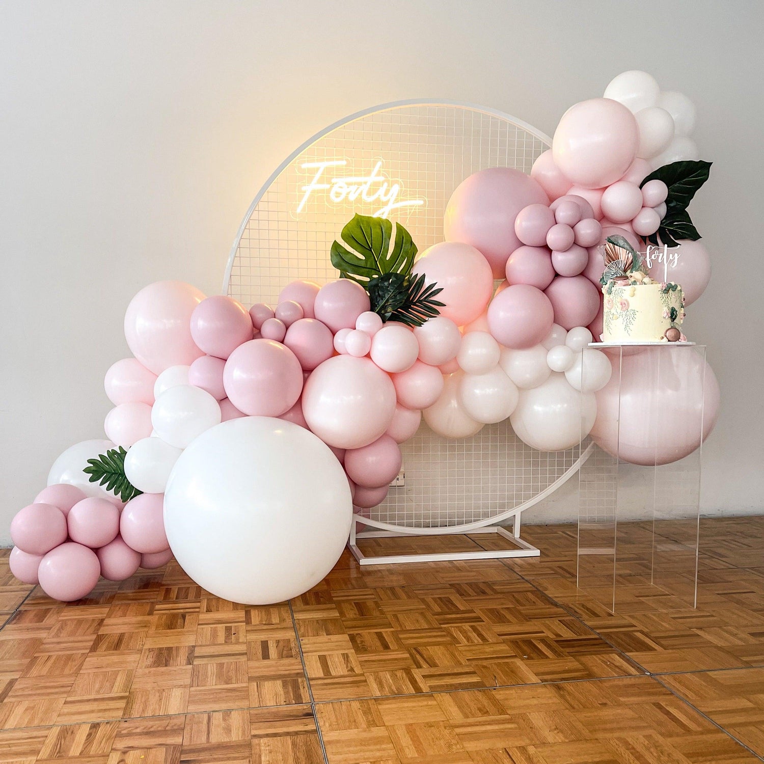 Pink and white balloon arch with neon sign for indoor event setup in Melbourne